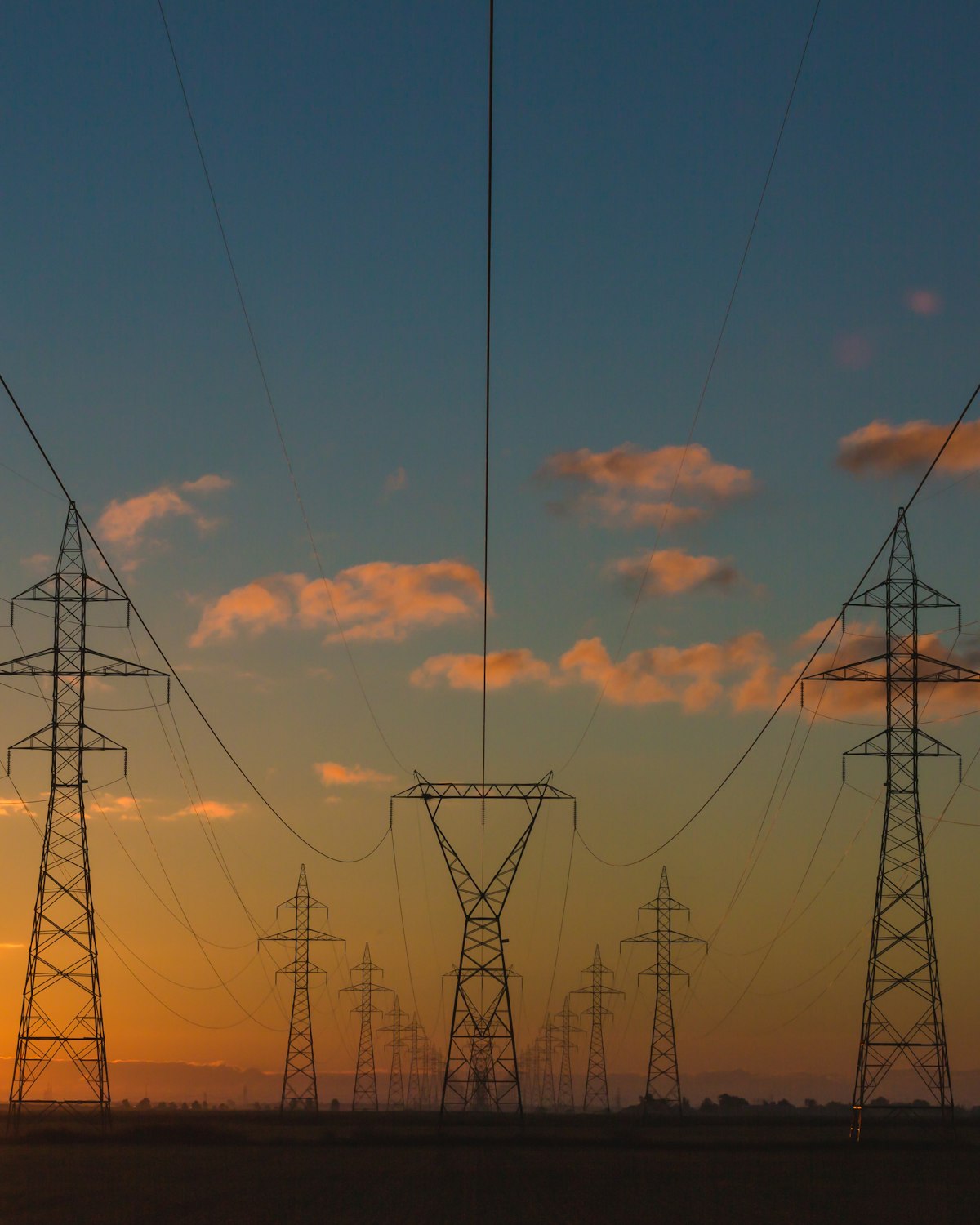 High-voltage transmission towers and power lines at sunset
